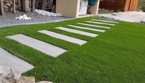 chemin pavé sur une pelouse synthétique