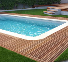 piscine avec bois et pelouse artificielle